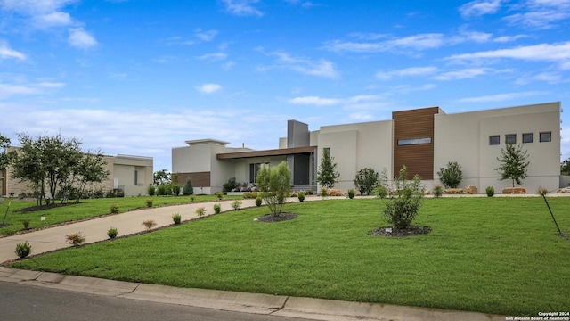 modern home with stucco siding, concrete driveway, and a front yard