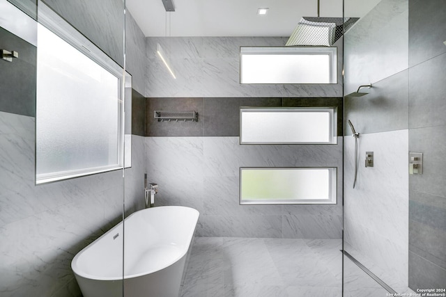 full bathroom featuring a wealth of natural light, a soaking tub, and a walk in shower