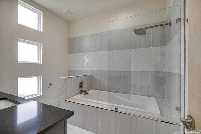 full bathroom featuring vanity, visible vents, tiled bath, and a tile shower