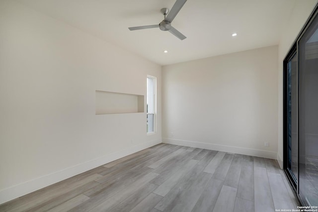 unfurnished room with recessed lighting, light wood-style flooring, a ceiling fan, and baseboards