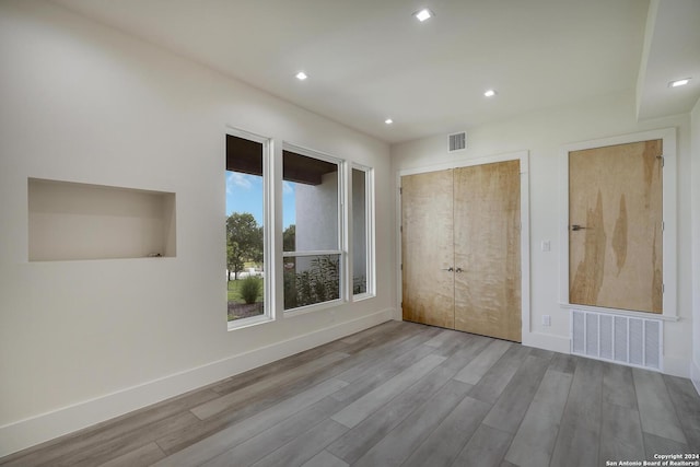 empty room featuring visible vents, baseboards, and wood finished floors