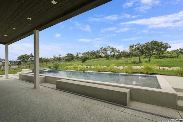 view of swimming pool with fence, a pool with connected hot tub, and a patio area