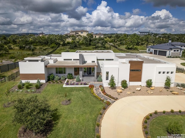 view of front of house featuring stucco siding, a garage, a front yard, and fence