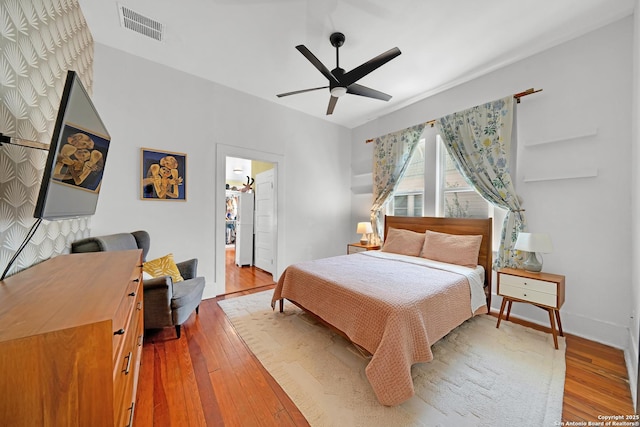 bedroom featuring visible vents, wood-type flooring, baseboards, and a ceiling fan