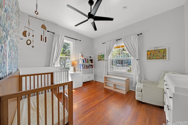 bedroom featuring multiple windows, wood-type flooring, and a ceiling fan