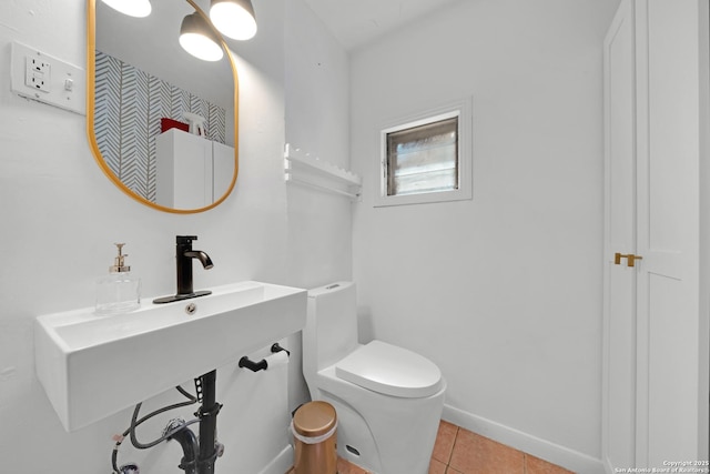 bathroom featuring tile patterned flooring, toilet, and baseboards