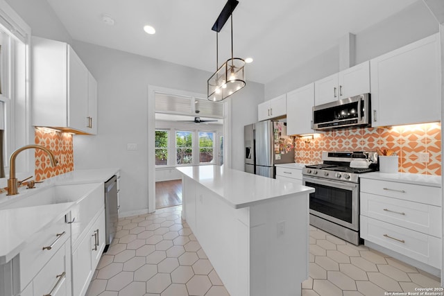 kitchen featuring a sink, tasteful backsplash, appliances with stainless steel finishes, and a kitchen island