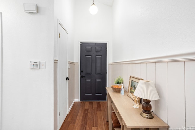 entryway with dark wood-style floors and wainscoting