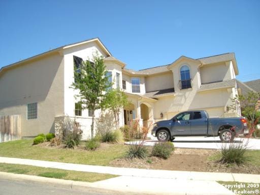 view of front of house with stucco siding, driveway, and a garage