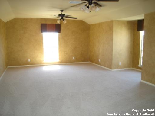 spare room with lofted ceiling, carpet flooring, baseboards, and ceiling fan