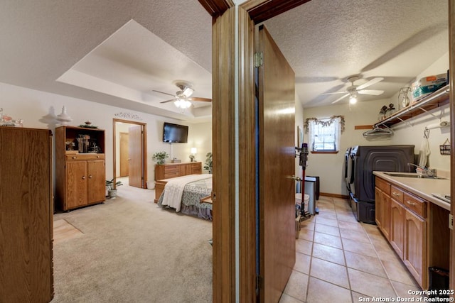 laundry area featuring ceiling fan, light tile patterned floors, washing machine and dryer, and a textured ceiling