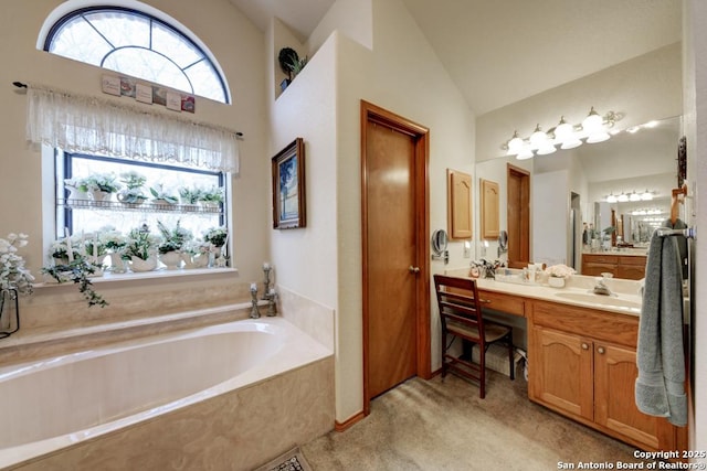 bathroom with vanity, lofted ceiling, and a bath