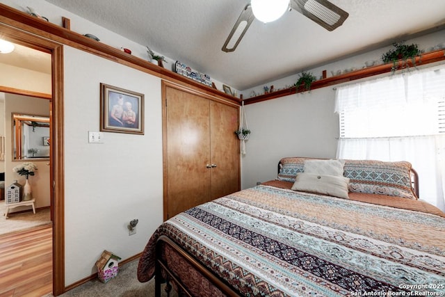 bedroom with ceiling fan, baseboards, a closet, and a textured ceiling