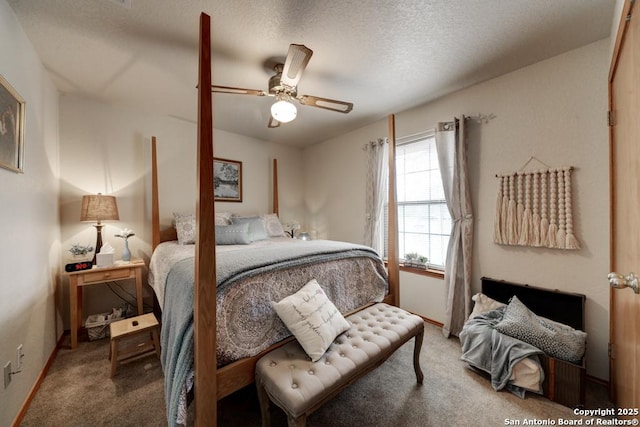 carpeted bedroom featuring a textured ceiling and a ceiling fan