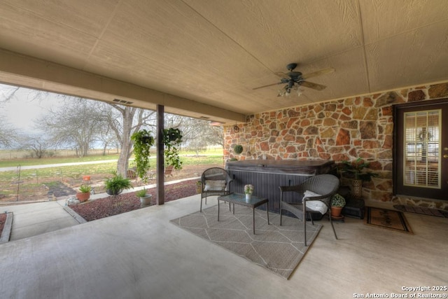 view of patio featuring a ceiling fan and a hot tub