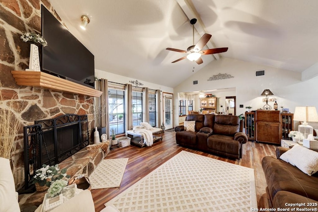 living room featuring beam ceiling, high vaulted ceiling, a ceiling fan, wood finished floors, and a fireplace