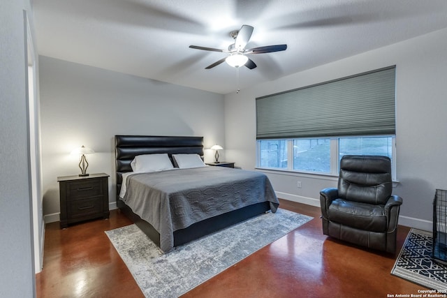 bedroom featuring a ceiling fan, baseboards, and concrete floors