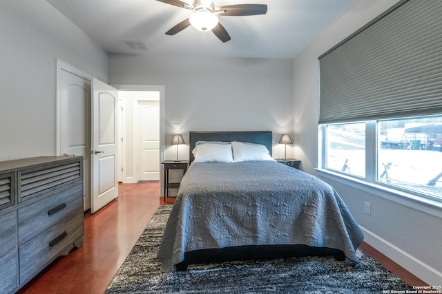 bedroom with a ceiling fan, baseboards, visible vents, and finished concrete floors