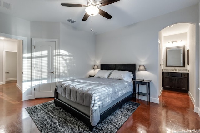 bedroom with a sink, visible vents, baseboards, and arched walkways