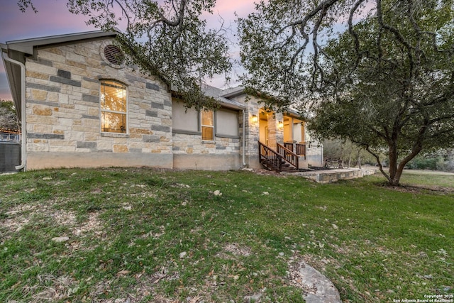 exterior space featuring a lawn and stone siding