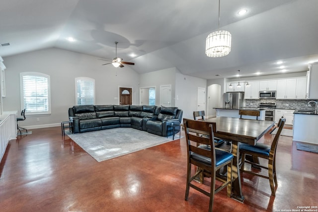 dining room featuring visible vents, baseboards, finished concrete floors, lofted ceiling, and ceiling fan with notable chandelier