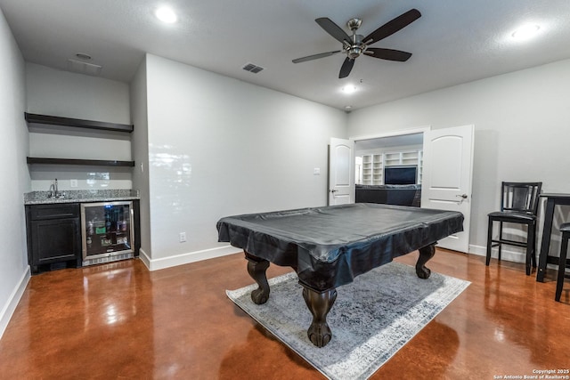 game room featuring beverage cooler, visible vents, concrete floors, baseboards, and indoor wet bar