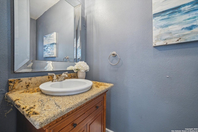 bathroom with vanity and a textured wall