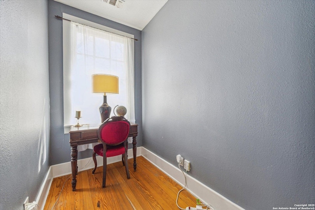 office area featuring visible vents, light wood-style flooring, and baseboards