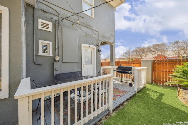 exterior space with a deck, fence, and a grill