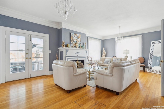 living area with light wood finished floors, a notable chandelier, plenty of natural light, and a fireplace