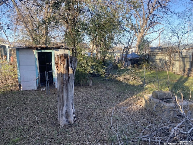 view of yard with an outbuilding, a shed, and fence