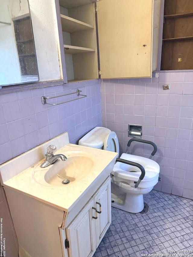 half bath featuring tile patterned floors, toilet, and vanity