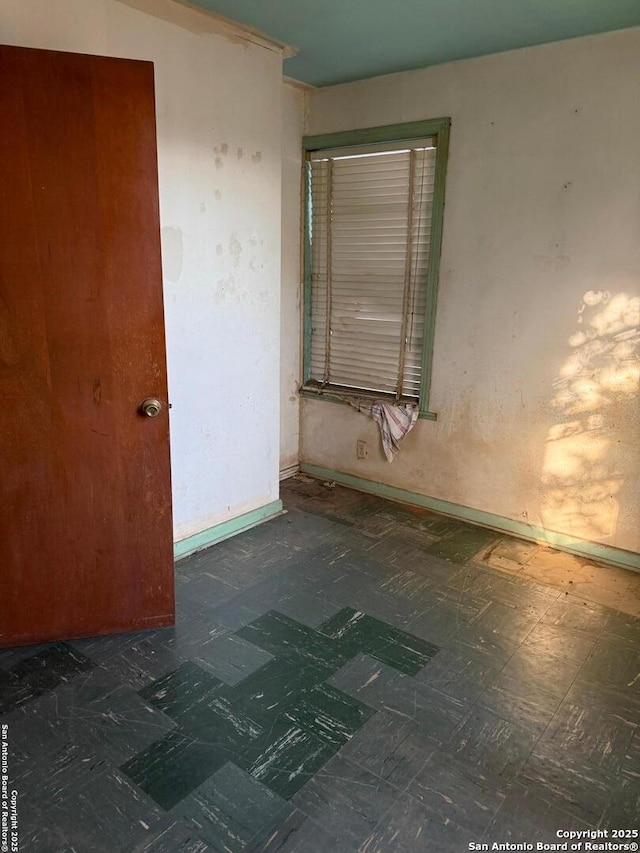 spare room featuring tile patterned floors and baseboards