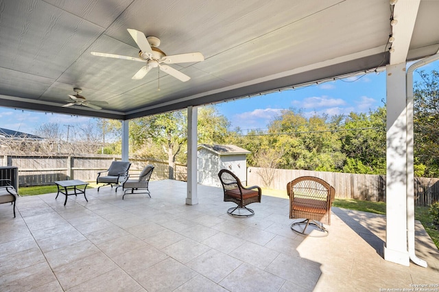 view of patio / terrace featuring an outbuilding, a storage unit, and a fenced backyard