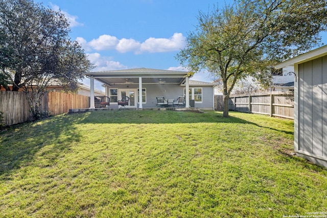 back of house featuring a lawn, a fenced backyard, a ceiling fan, and a patio area