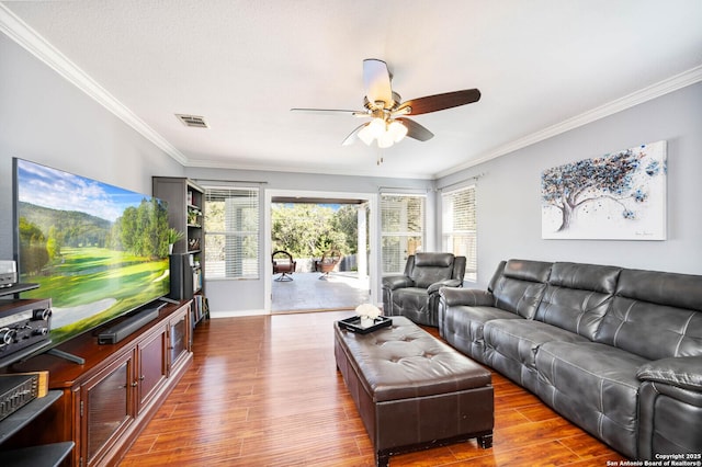 living area with visible vents, crown molding, ceiling fan, and wood finished floors