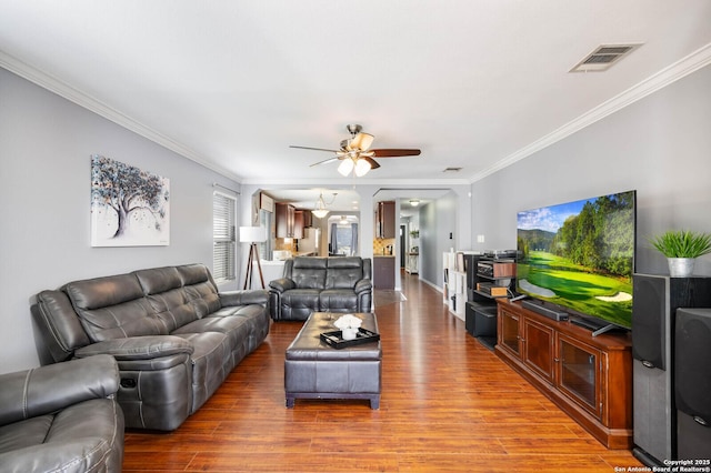 living room featuring visible vents, wood finished floors, and ornamental molding