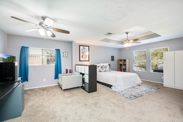 bedroom featuring a raised ceiling, multiple windows, visible vents, and carpet floors