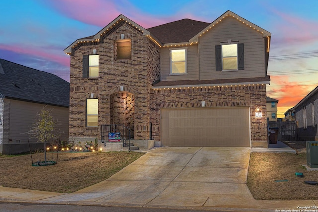 traditional home with a garage, brick siding, and concrete driveway