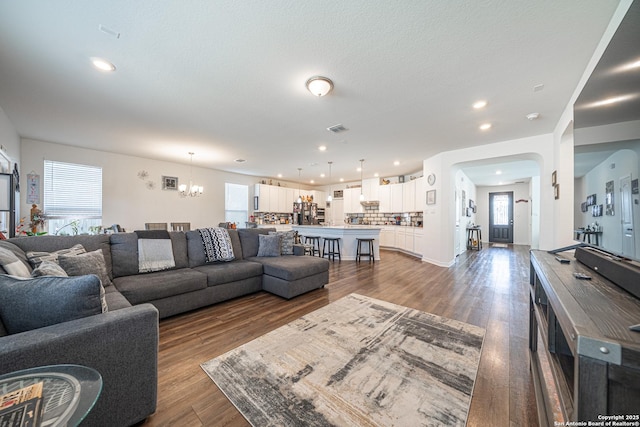 living room with dark wood finished floors, an inviting chandelier, recessed lighting, and visible vents