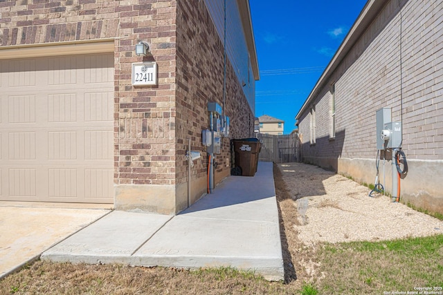 view of property exterior with fence and brick siding