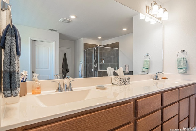 bathroom featuring double vanity, visible vents, a stall shower, and a sink