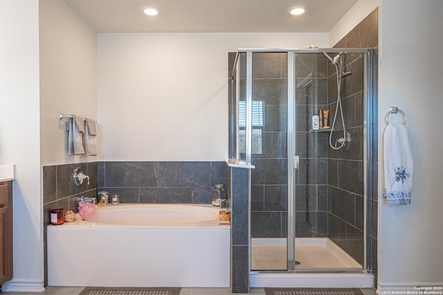 full bath featuring a shower stall, vanity, and a garden tub