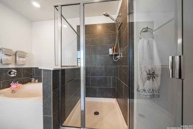 bathroom featuring a stall shower and a bath