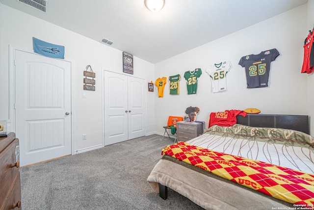 carpeted bedroom with visible vents, baseboards, and a closet