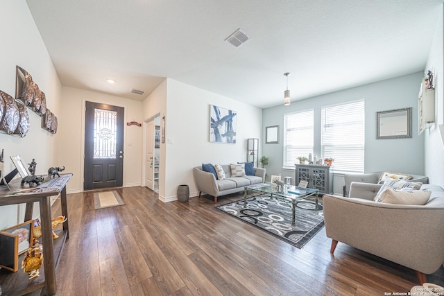 living room featuring visible vents, baseboards, and dark wood-type flooring