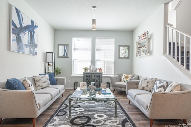 living area featuring stairway, baseboards, and dark wood-style floors