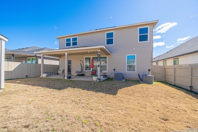 rear view of property featuring a patio, central AC unit, and a fenced backyard