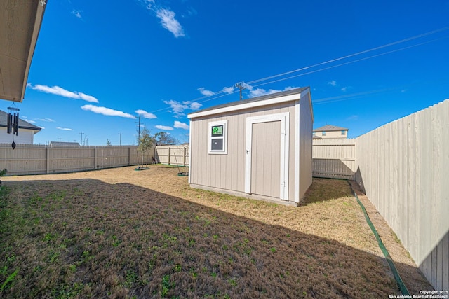 view of yard with a storage unit, an outbuilding, and a fenced backyard