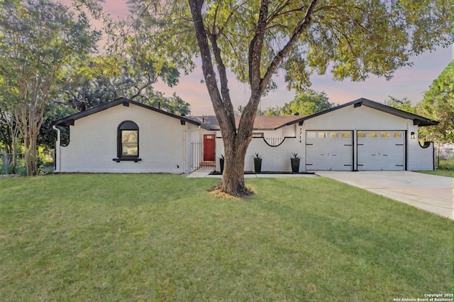 view of front of house with brick siding, an attached garage, concrete driveway, and a front yard